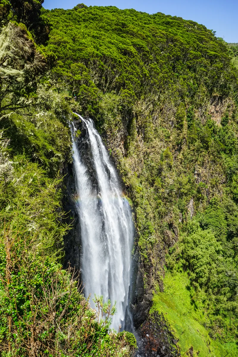 A tall waterfall plunging over a green cliff in Aberdare National Park