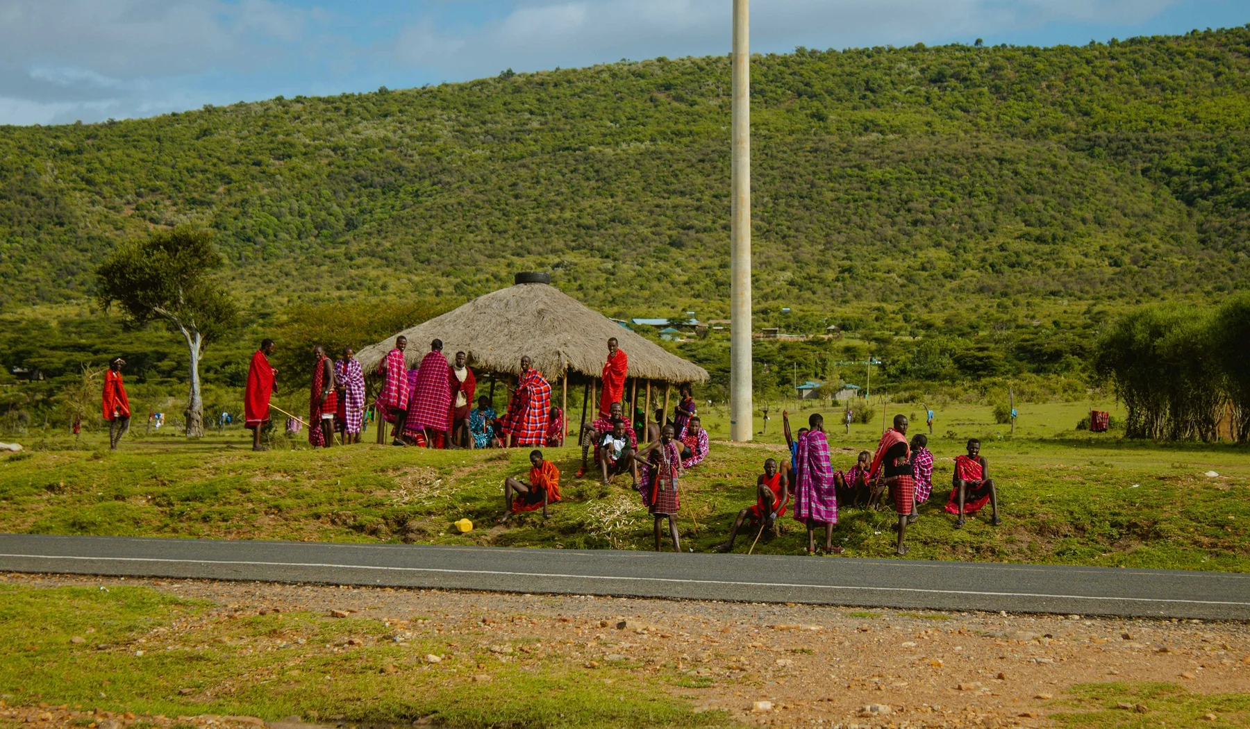 Maasai hosts and visitors gathered near a homestead in the Masai Mara