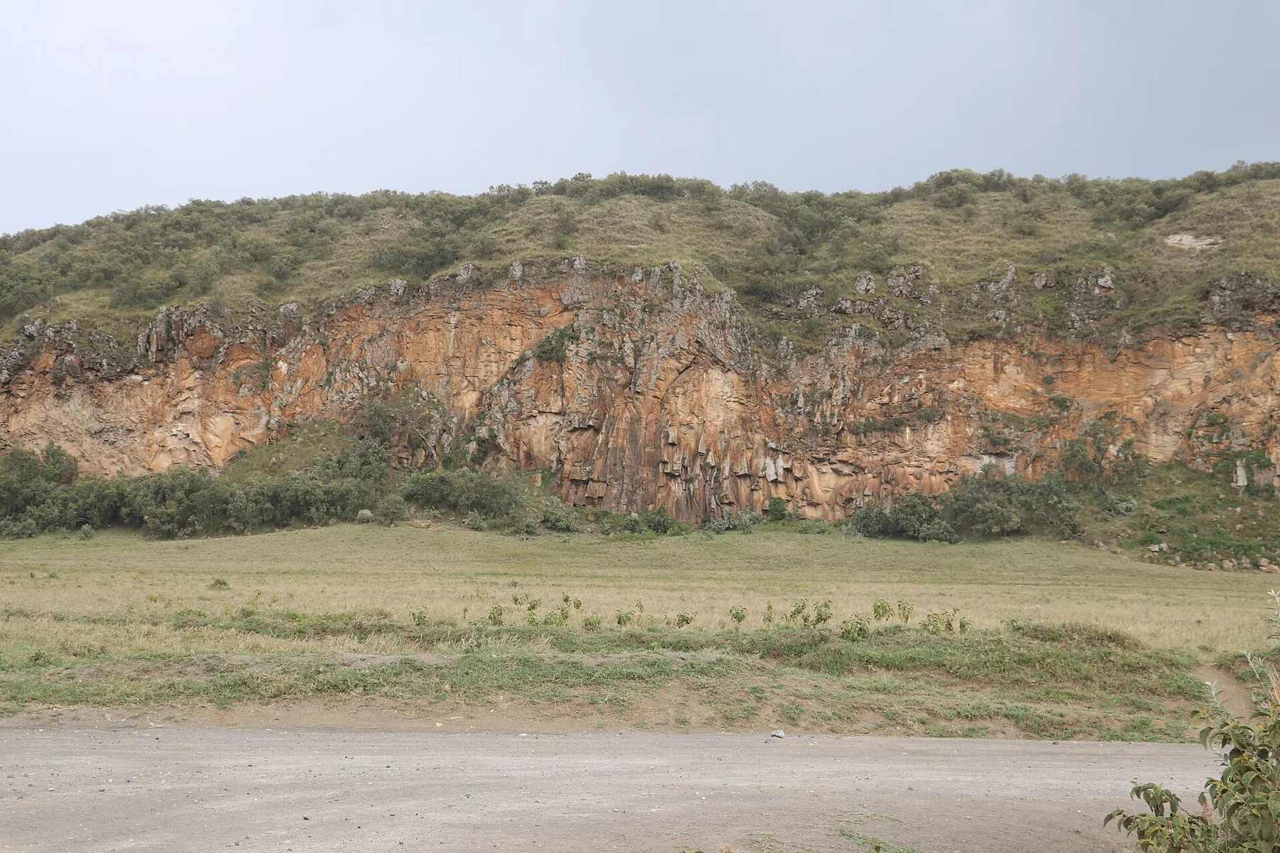 Orange and grey volcanic cliff face inside Hell's Gate National Park