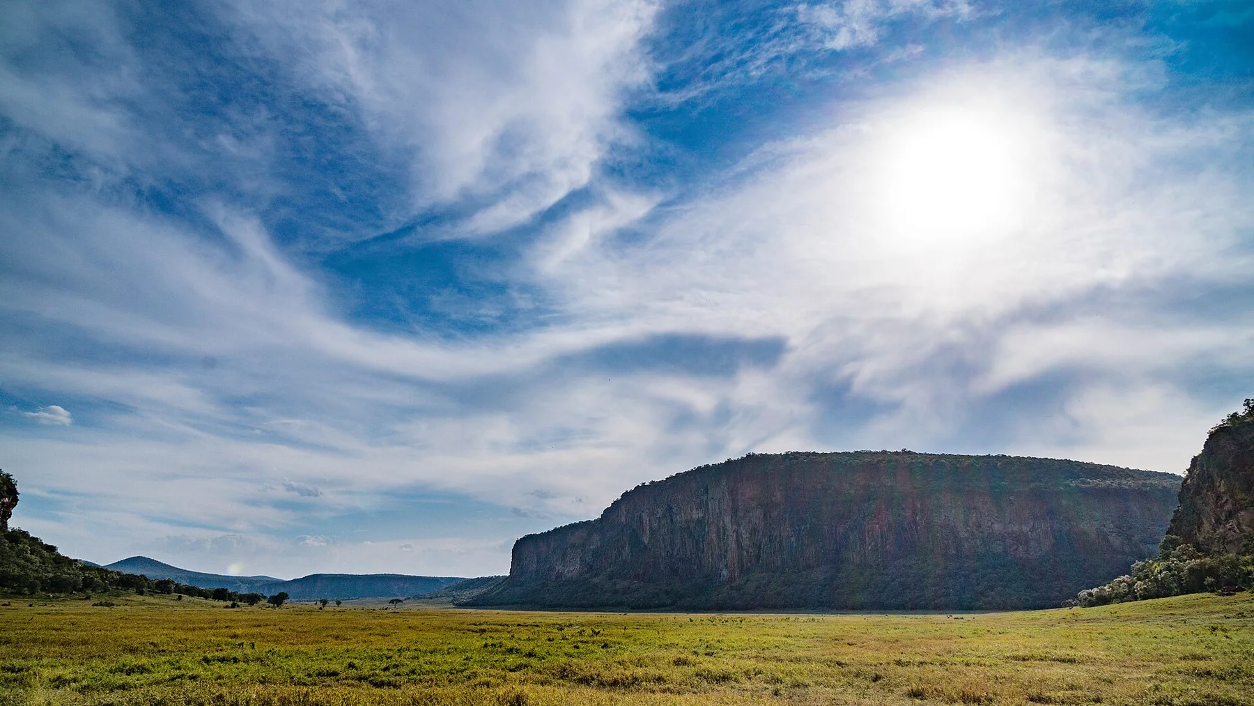 Wide grassland and volcanic cliffs inside Hell's Gate National Park