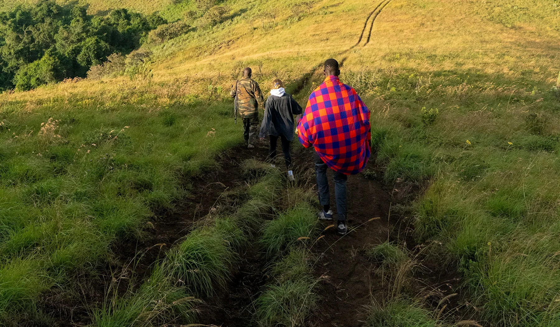 Small group walking with local guides on a grassy Kenyan hill