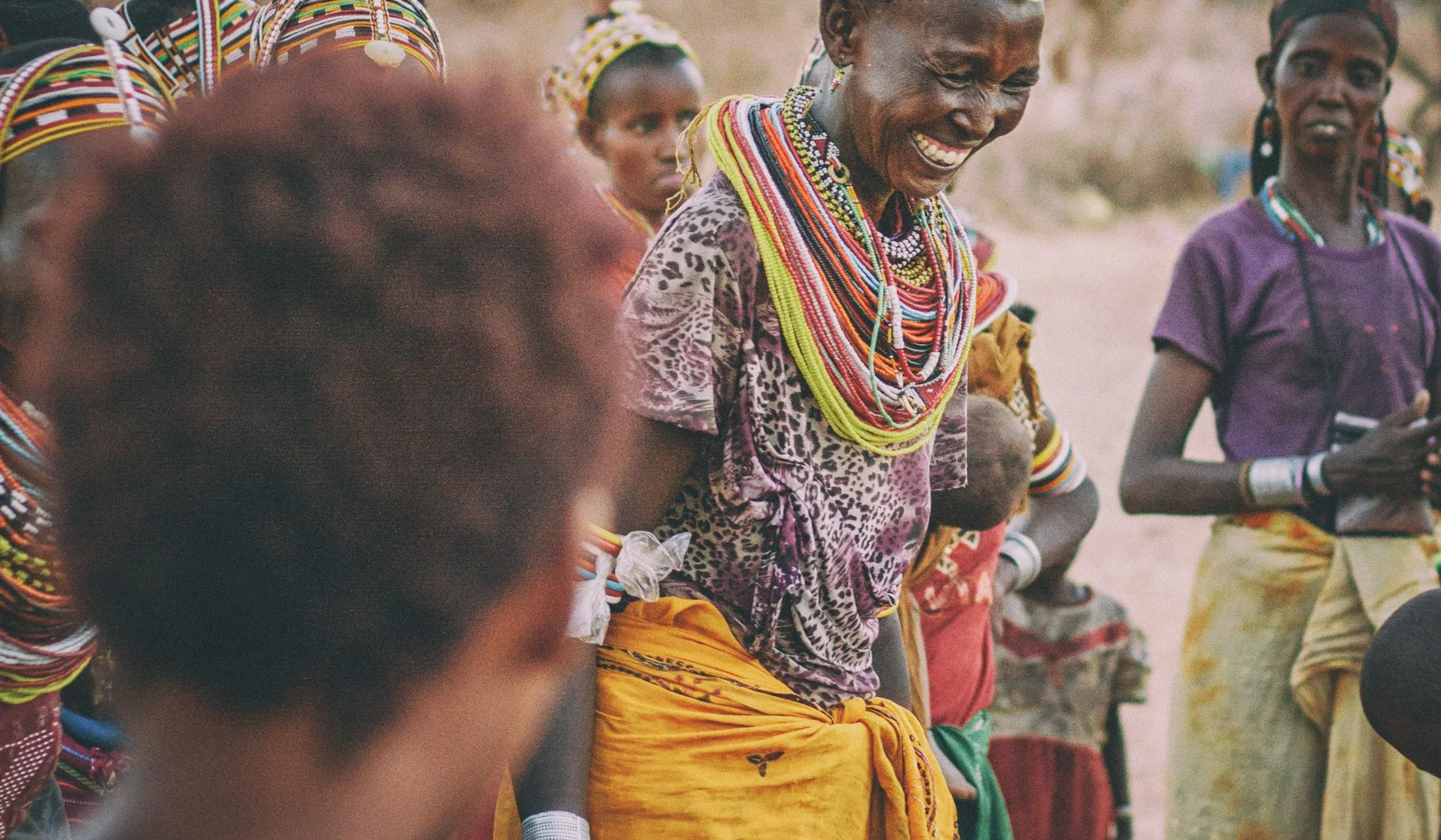 Smiling Maasai woman among community members