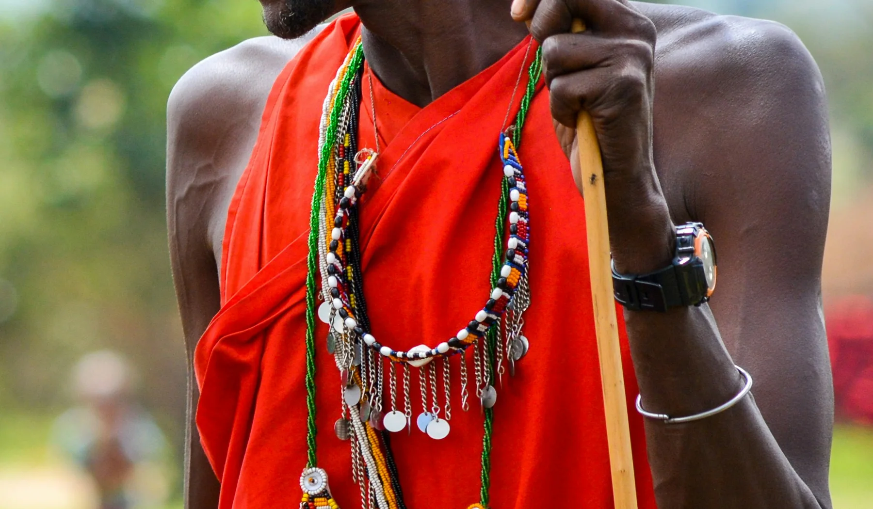 Maasai man in red clothing holding a staff