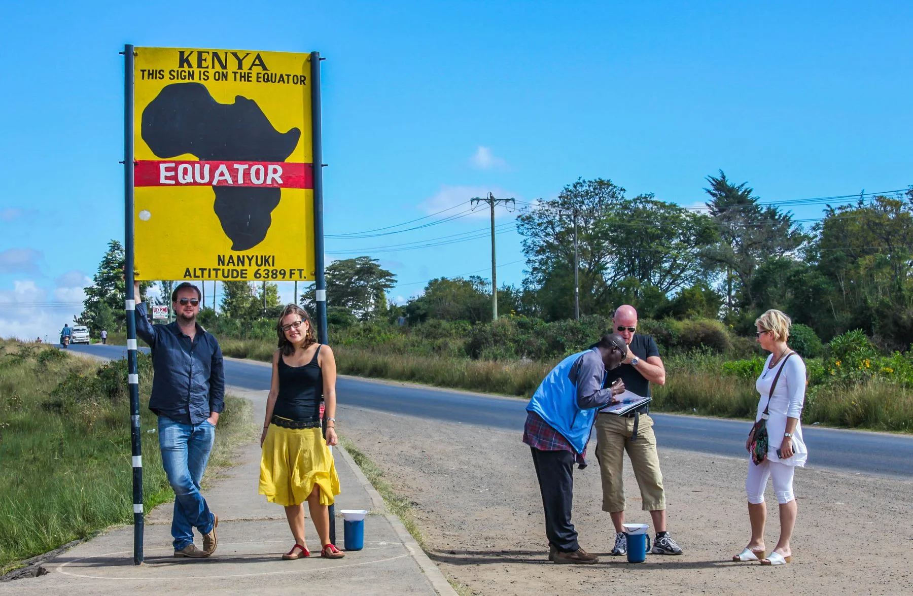 Travellers beside the equator sign on the A2 road near Nanyuki
