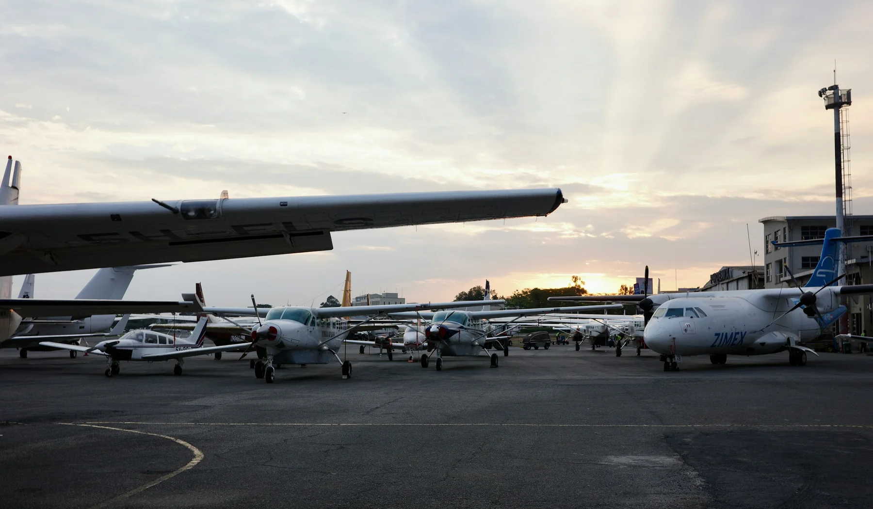 Several small aircraft parked at Wilson Airport in Nairobi at sunset