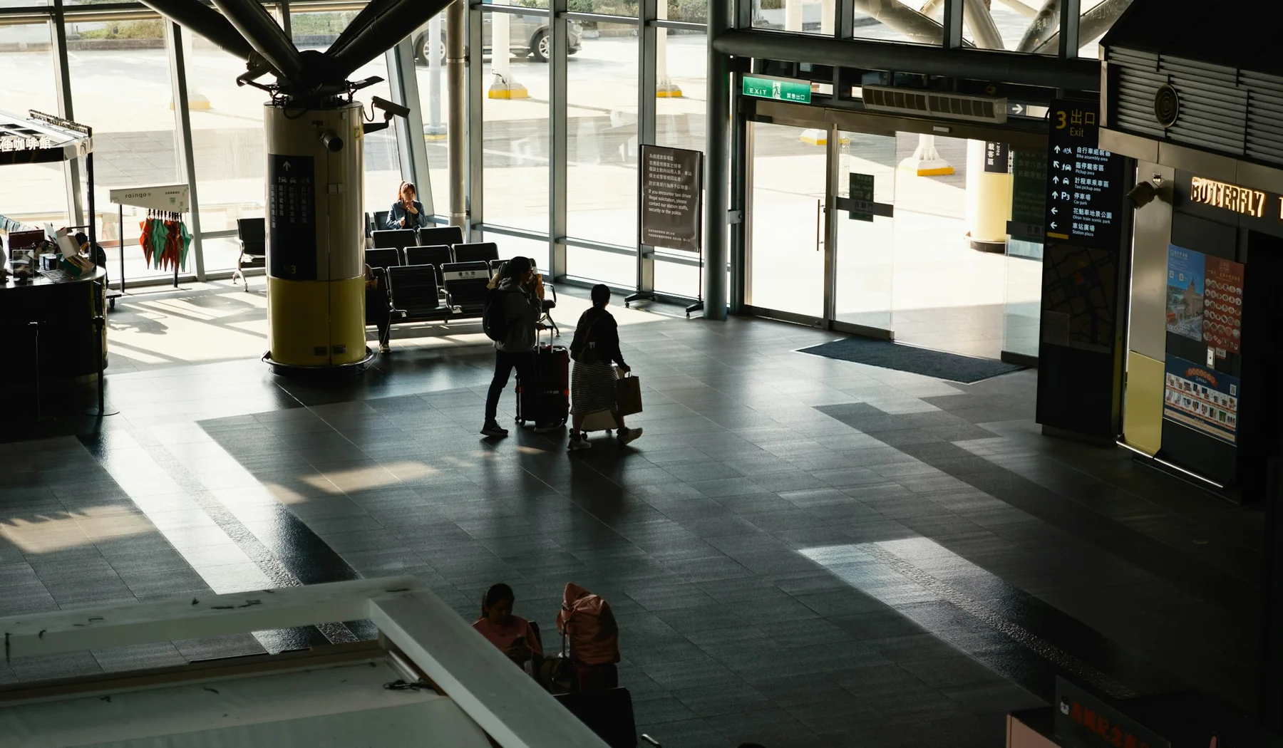 Passengers walking with luggage inside an international airport terminal