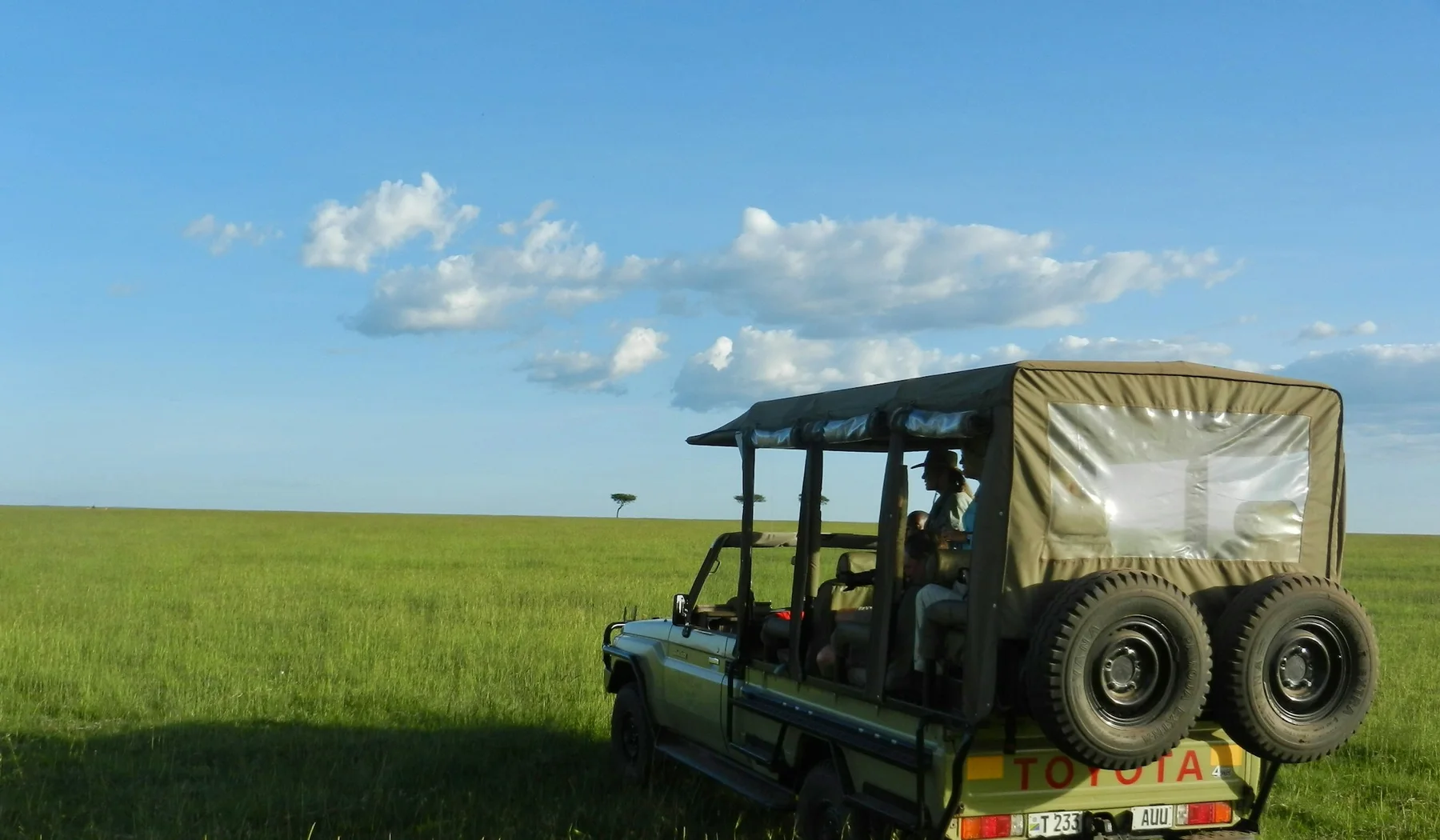 Safari vehicle on a bright game drive in the Masai Mara