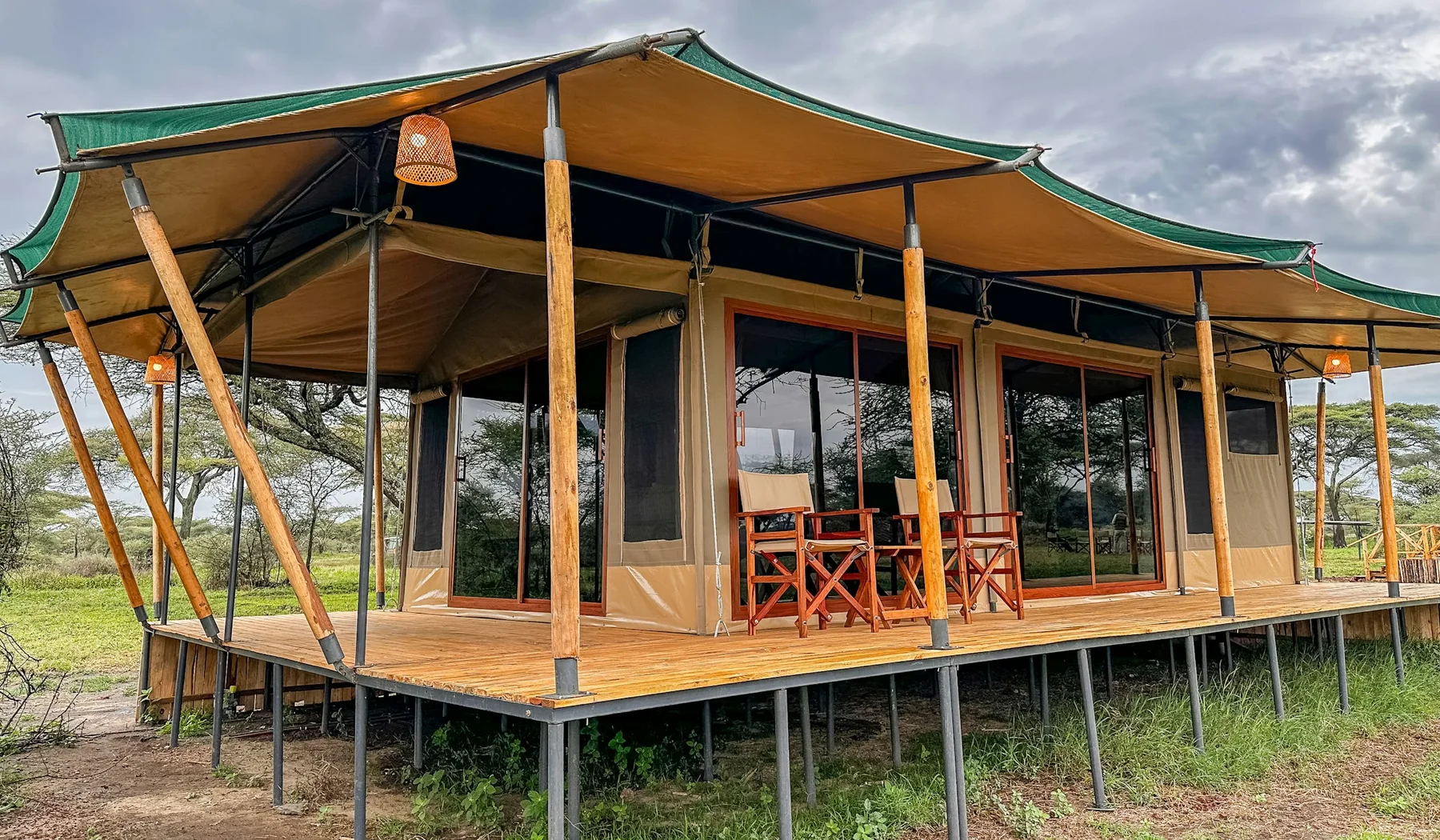 Canvas safari tent with a furnished porch surrounded by vegetation